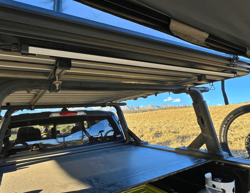 Kingpin v-Series 40" LED light mounted under truck bed rack and roof top tent of ford ranger carry mountain bikes in the mountains